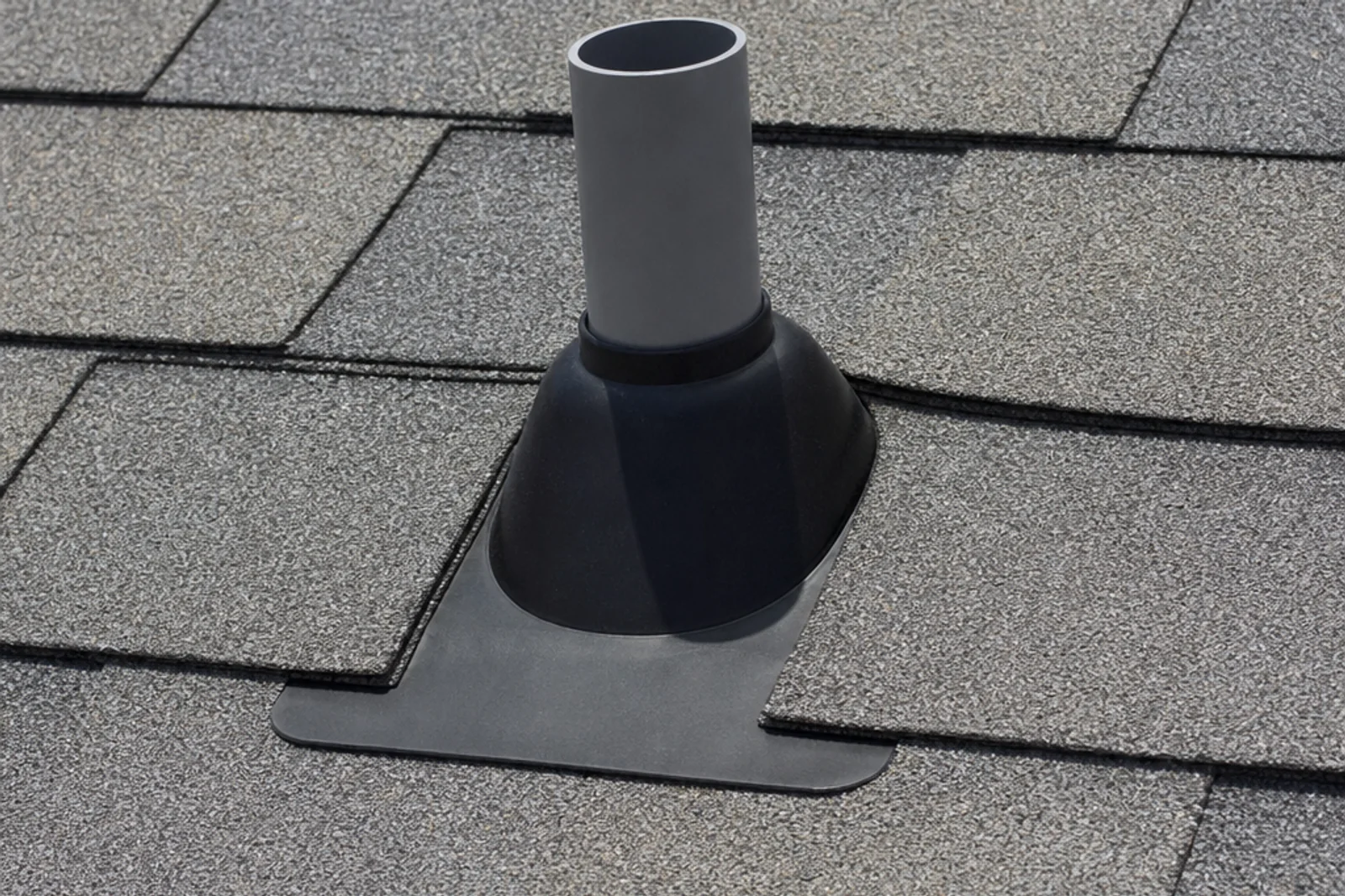 Pipe boot and metal flashing integrated with overlapping asphalt shingles.
